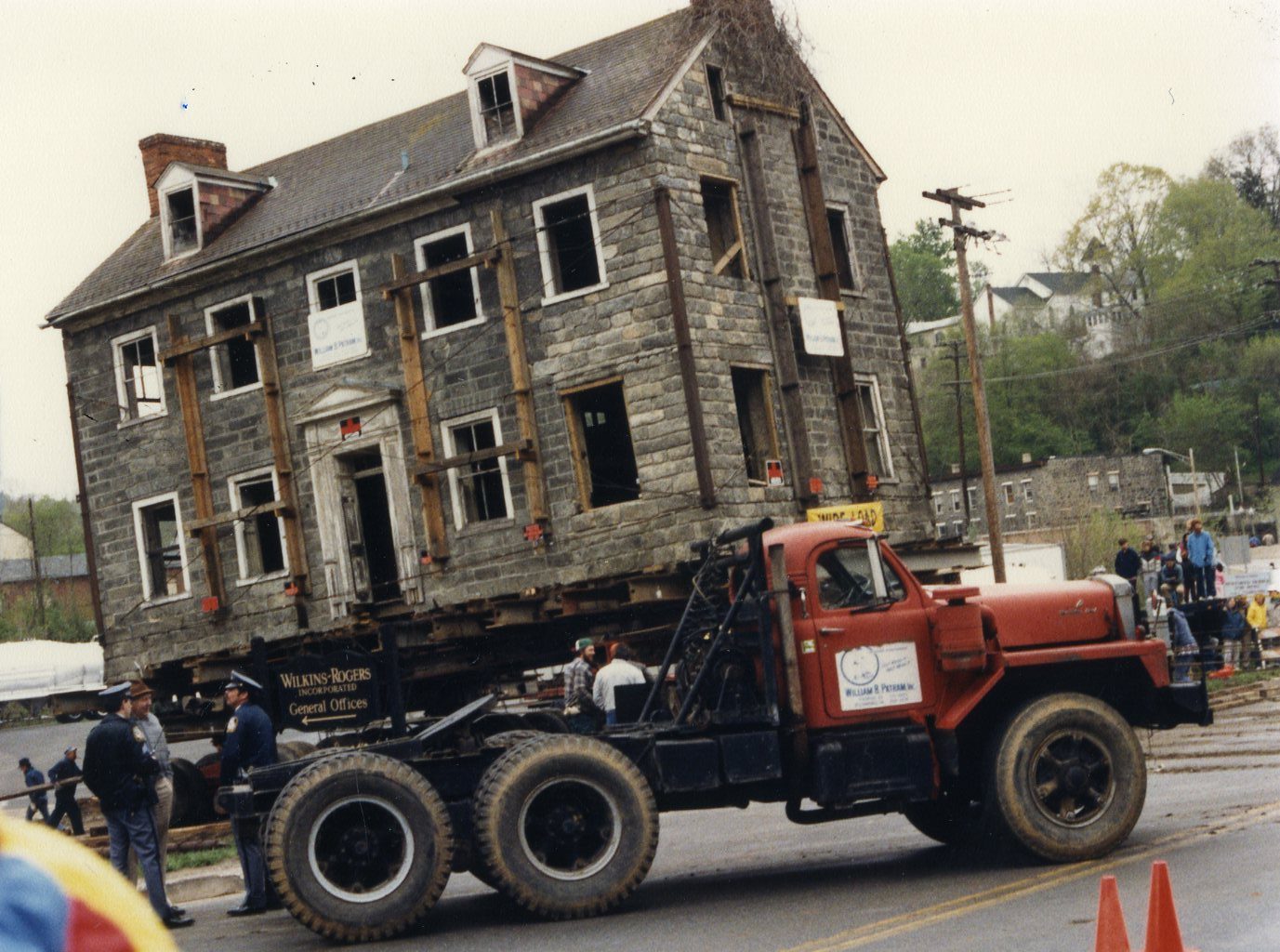 Exterior shot of the George Ellicott House in Oella, MD being moved to higher ground following Hurricane Agnes, in 1987. Scanned from the Preservation Maryland physical photograph collection.